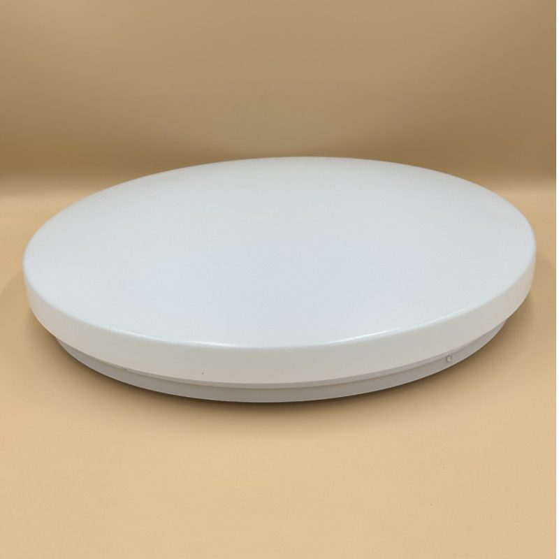 White circular disc device with a thin base resting on a beige surface.