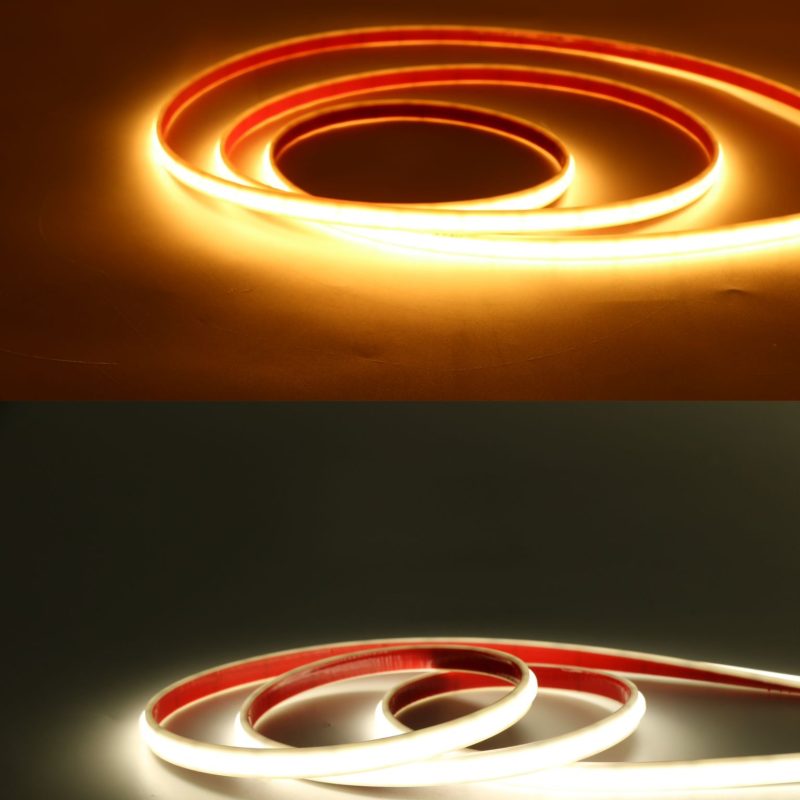 Coiled glowing neon light tubes in orange and white forming spirals on a dark surface.