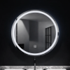 Round LED-lit bathroom mirror above a sink with a chrome faucet, reflecting a dim room.