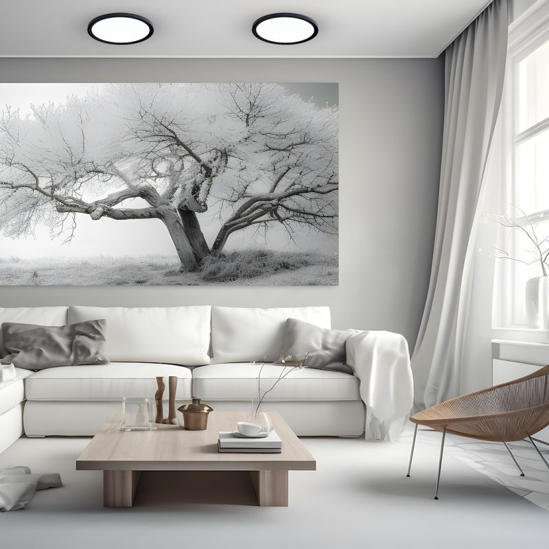 Living room with a large black-and-white tree artwork above a white sectional sofa.