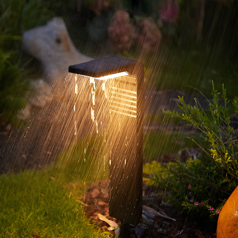 Wooden outdoor garden light post glowing warmly as heavy rain falls around it.