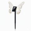 Solar-powered garden stake light with glittery butterfly wings attached to a black stake? not question