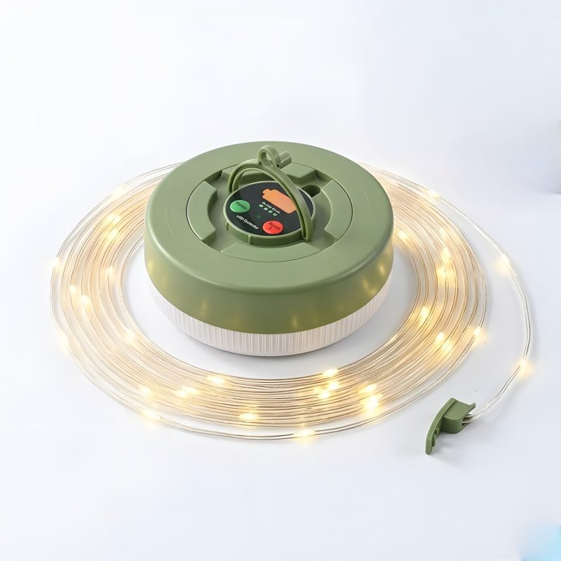 Green circular reel with a coil of warm-white LED string lights wrapped around it, with a small control panel on top and a detachable plug nearby.
