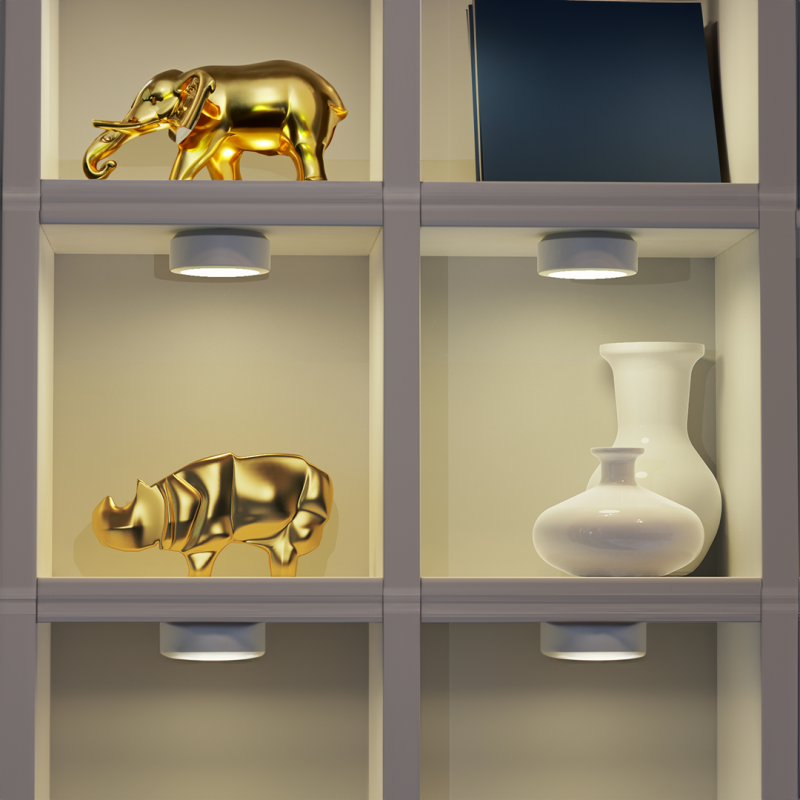 Decorative shelf display with gold animal sculptures (elephant and rhinoceros) and white ceramic vases with a blue book nearby.