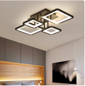 Contemporary ceiling light with interlocking square rings, illuminating a bedroom with a gray cabinet wall and wooden headboard.