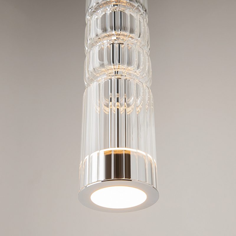Clear glass cylindrical pendant light with an integrated LED, hanging from the ceiling