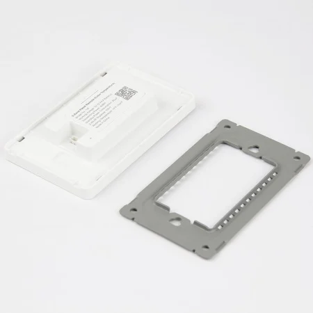White plastic electronic module with an attached cable beside a gray metal mounting frame on a white background.