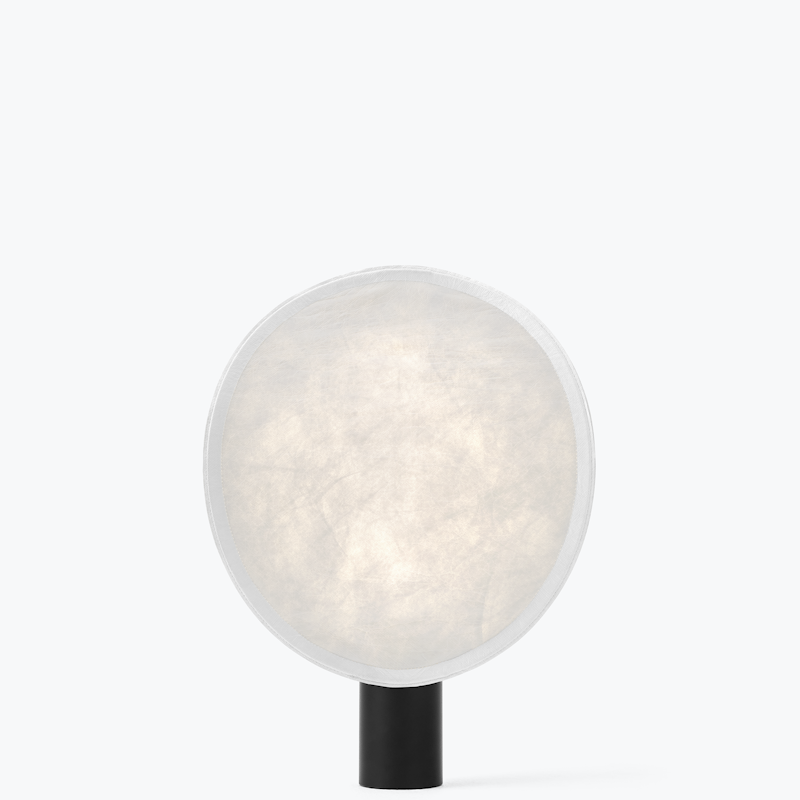 Small modern table lamp with a large round frosted shade and a short black base.