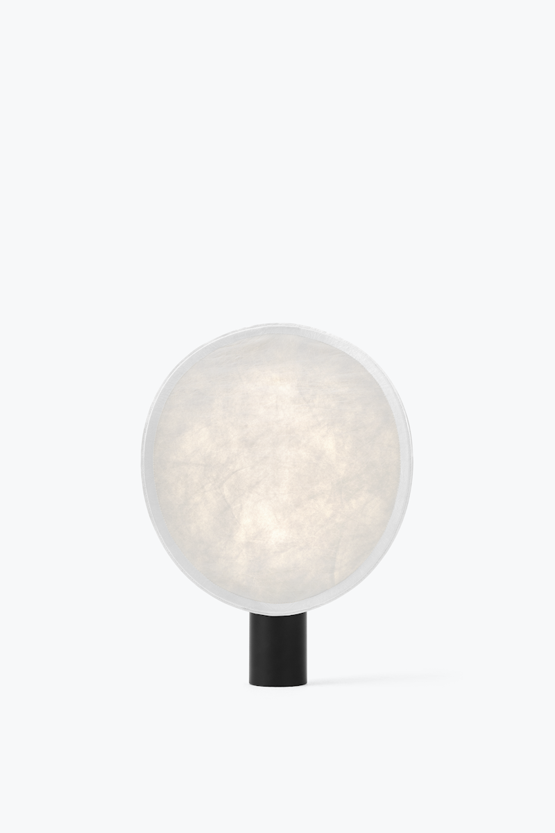 Small modern table lamp with a large round frosted shade and a short black base.