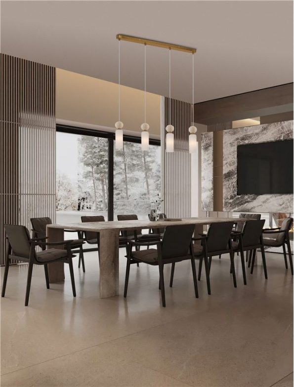 Modern dining room with a long wooden table, dark upholstered chairs, and a row of pendant lights, a marble accent wall, and large windows showing a snowy outdoor scene.