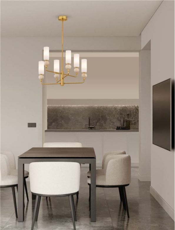 Modern dining area with a dark rectangular table, four white upholstered chairs, and a gold chandelier above; open kitchen with gray marble backsplash in the background.