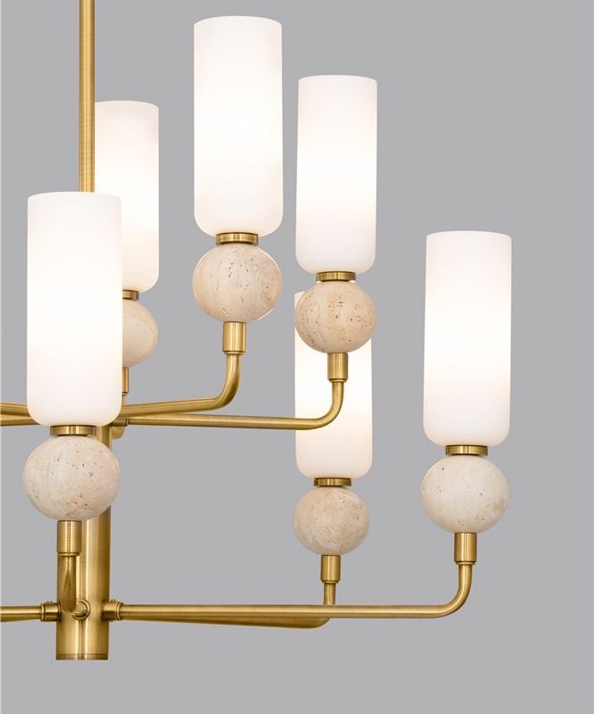 Brass chandelier with cylindrical white shades and stone-like spheres on a gray backdrop, decorative lighting fixture used in interiors.