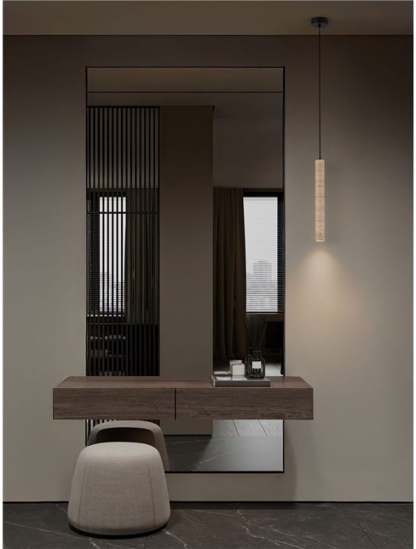 Contemporary vanity area with a wall-mounted wooden console, a large mirror, beige pouf stool, and a pendant light against a dark marble floor.