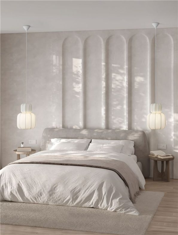 Elegant neutral bedroom with tall arched wall panels, a plush bed, and hanging pendant lamps at each side.