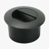 Black cylindrical plastic plug with a recessed top and a horizontal slot, likely a snap-in furniture or hardware cover used to conceal an opening.