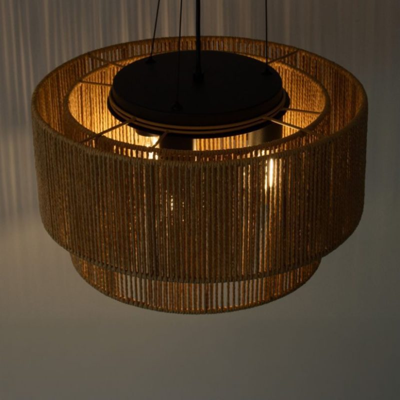 Hanging wicker pendant lamp with a warm light glowing inside, casting a soft glow downward.
