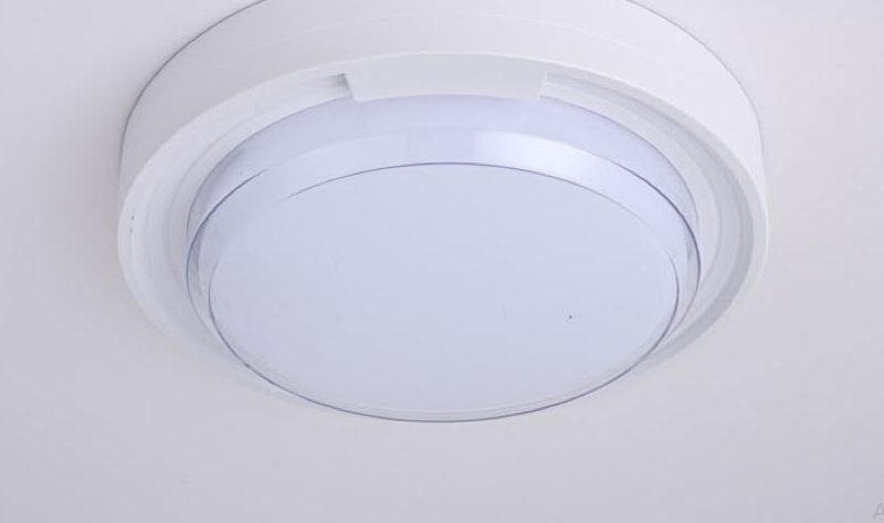White circular ceiling-mounted smoke detector on a light ceiling.