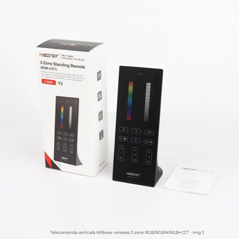 Vertical black wireless remote for MiBoxer 3-zone RGB+CCT lighting, with color bar and numeric keypad, beside its box.